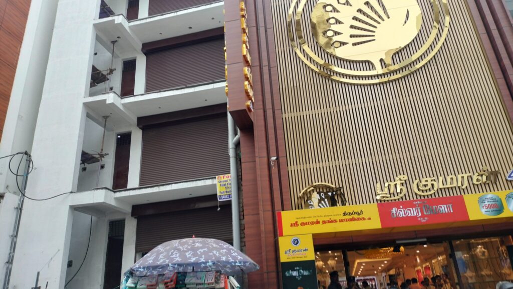 exterior view of commercial building for rent in tirupur's main bazaar with the nearby famous sri kumaran thanga maaligai jewellery store